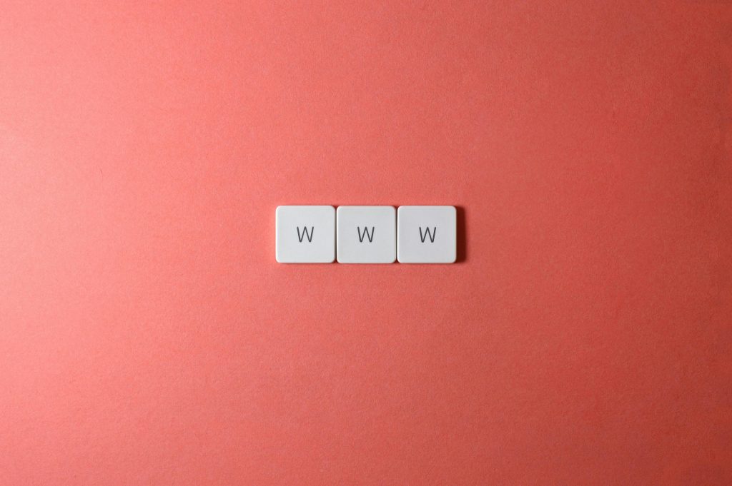 Close-up of WWW keyboard keys on a vibrant red surface, ideal for digital concepts.